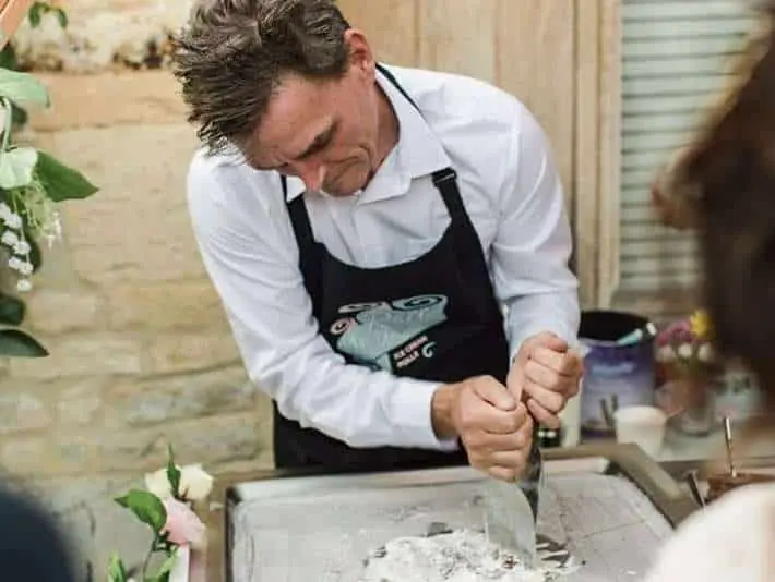 man making ice cream rolls at wedding